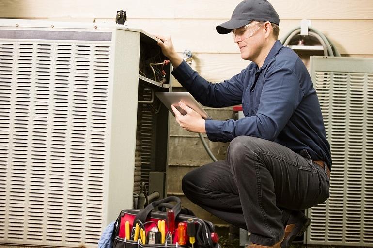 FNB Air conditioner repairman works on home unit GettyImages 489211146
